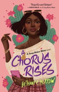 cover of A Chorus Rises, by Bethany Morrow: a stylish Black girl with short hair, hoop earrings, and a white off-the-shoulder top stands in front of green cactuses on a pink background